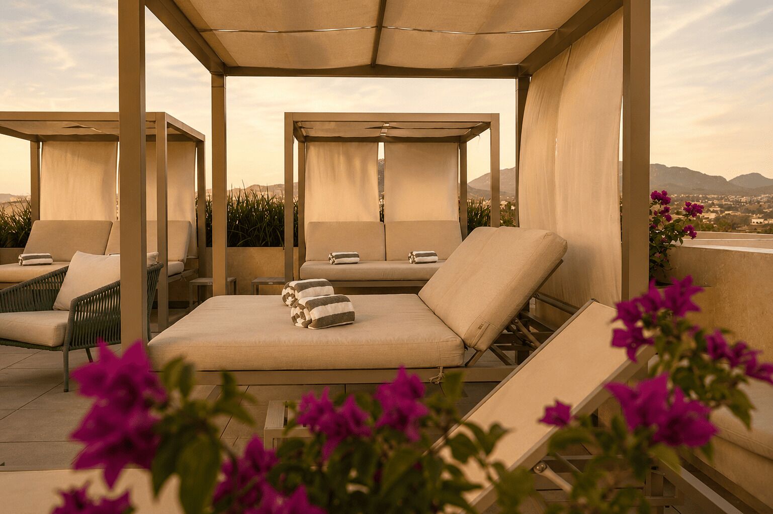Zona relax sul tetto con diverse opzioni di seduta, tra cui poltrone e un divano, sotto una tenda.