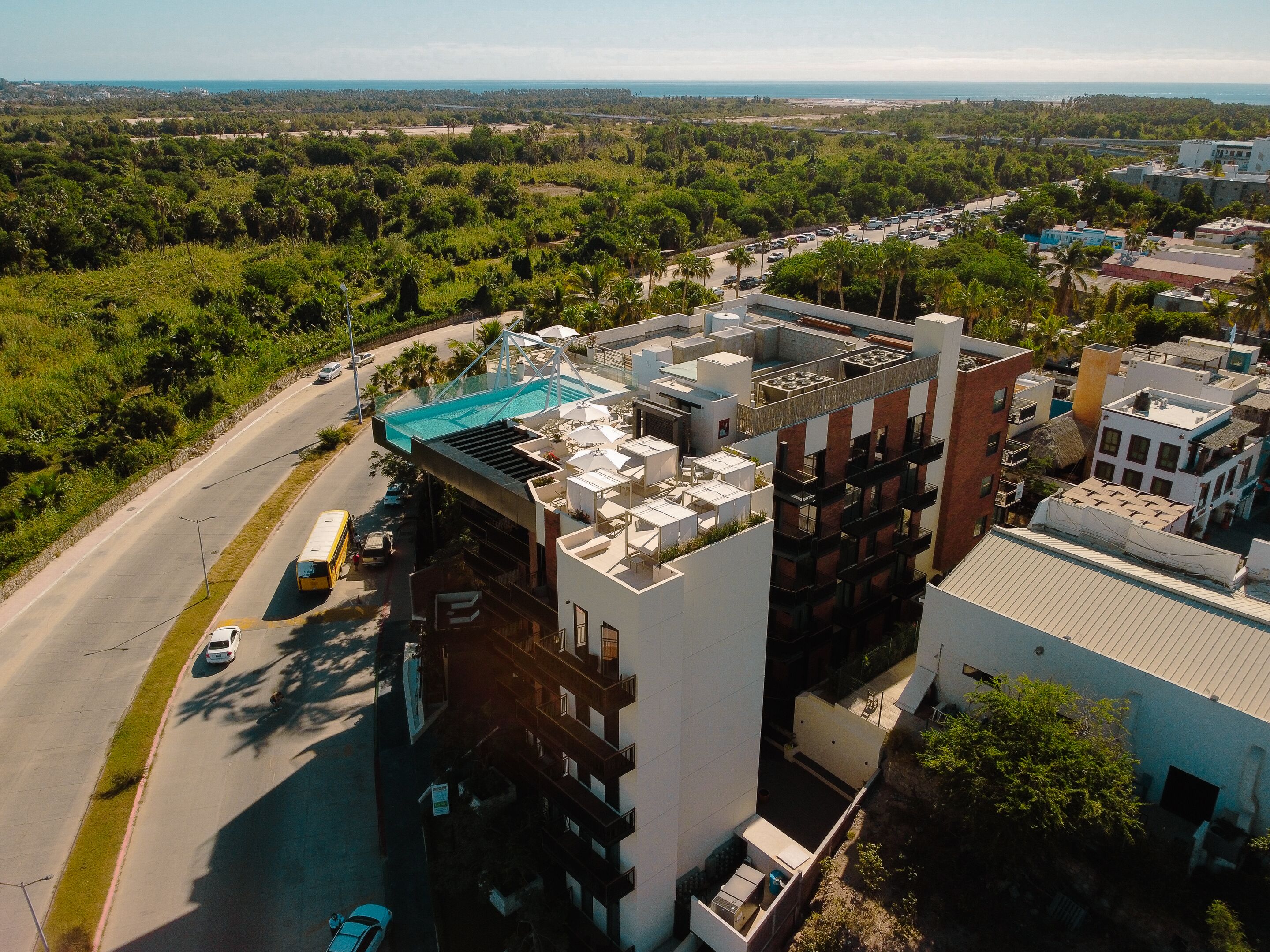 A modern building with a rooftop pool and multiple balconies.