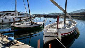 Een jachthaven met verschillende boten afgemeerd, kalm water en een heldere lucht.