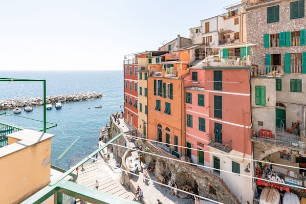 A coastal town with colorful buildings, a rocky shoreline, and boats in the water.