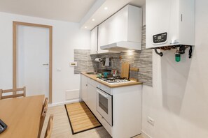 A compact kitchen with a stove, oven, and modern cabinetry. - Our delightful apartment is ideal for 4 people and is located in a privileged position at the small port of Riomaggiore, which gives its guests the opportunity to enjoy a fantastic experience in the heart of the 5Terre at its best!The characteristic terr (Riomaggiore)