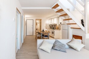 A modern interior with a sofa, dining table, and kitchen area.