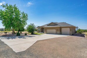 A residential house with a driveway, garage, and landscaping.