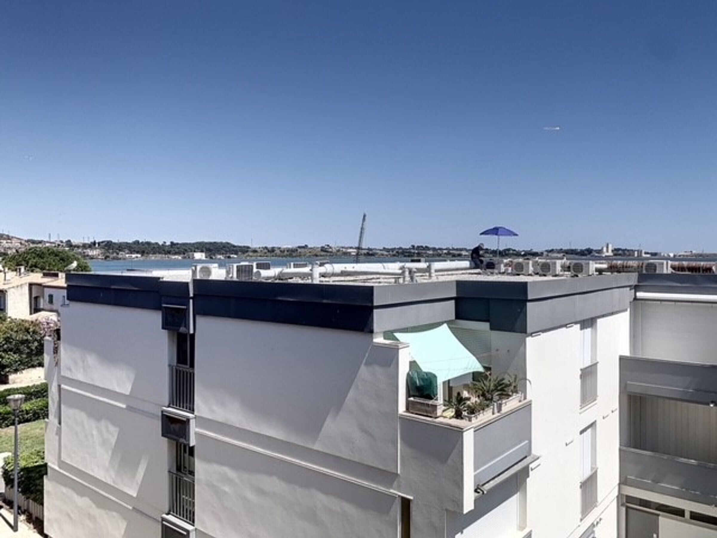 Un bâtiment moderne doté d’un toit plat, de grandes fenêtres et offrant une vue sur la mer.