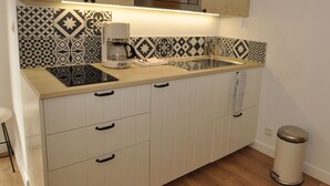 Una cocina con microondas, cafetera y un salpicadero decorativo.