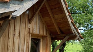 A wooden cabin with a sloped roof, a window, and a door. - L'Hermitage, an old stone shepherd's hut (Salvagnac-Cajarc)