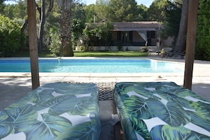 A pool area with two lounge chairs, a tiled pool, and a building in the background. - Villa with Private Pool + Spa Included – Provence (salon de provence)