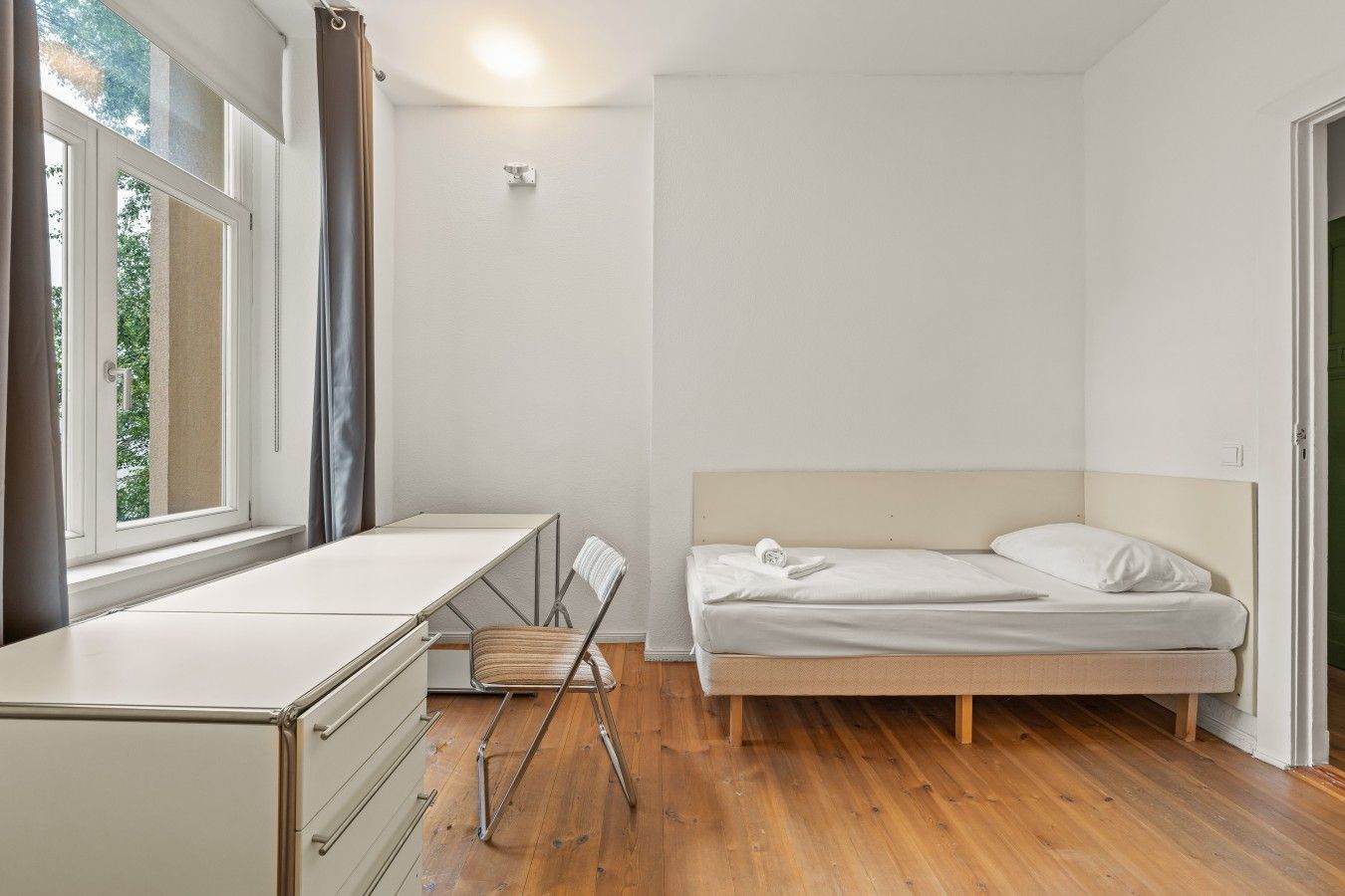 Ein Schlafzimmer mit einem Bett, einem Schreibtisch und einem Stuhl.