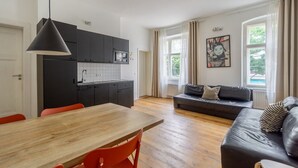 A modern apartment with a kitchen, dining area, and living room. - Boxi 6 pax - Roomy Apartment with balcony (Berlin)