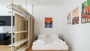 A modern hotel room with a bed, a wardrobe, a small table, and a picture of Berlin. - Boxi Beautifull Studio with patio (Berlin)
