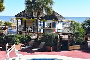 Relax by the ocean at this beachfront property, featuring a pool and a thatched-roof bar or lounge.