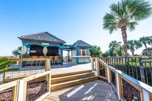 A two-story house with a blue exterior and a wooden deck.