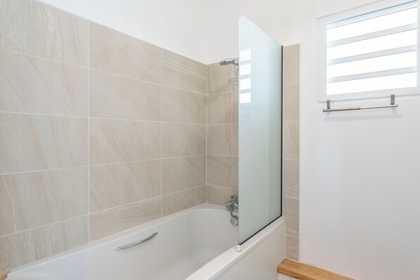A modern bathroom with a glass-enclosed shower, beige tiles, and a wooden floor. - Rooftop & spa Sainte Anne (Sainte-Anne)