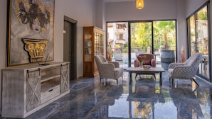 A spacious lobby with a marble floor, a wooden cabinet, a bookshelf, and a seating area with patterned chairs and a table. - Ada Butik Hotel (Marmaris)