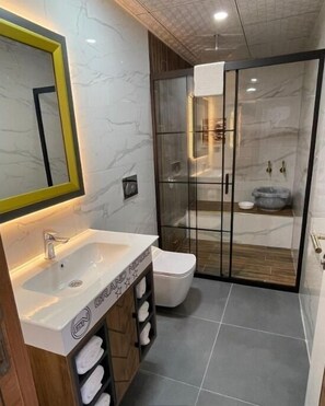 Quarto superluxo | Banheiro | Chuveiro, chuveiro com efeito de chuva, produtos de toalete de grife 
