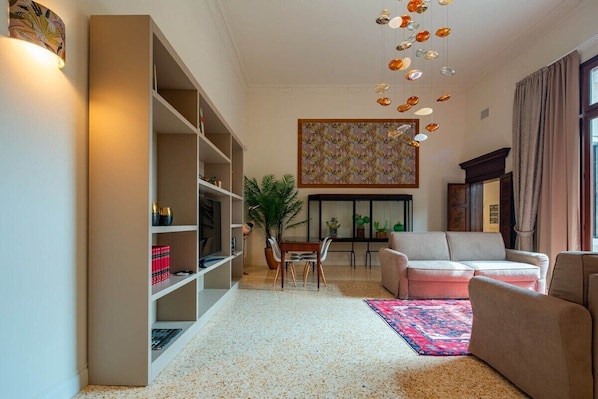 A living room with a sofa, a coffee table, and a bookshelf.