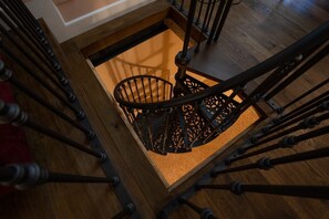 A spiral staircase with a wooden frame and metal balusters.