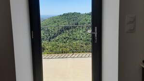 A door leading to a balcony with a view of a green hillside. - Pretty house in southern Ardèche with view, in Cévennes hamlet (Lentillères)