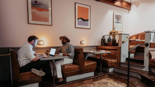 A restaurant with leather booths, a marble floor, and artwork on the walls. - Selina Chicago (Chicago)