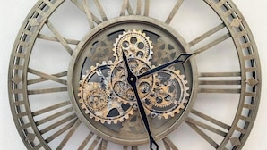 Een wandklok met een rond ontwerp en Romeinse cijfers.