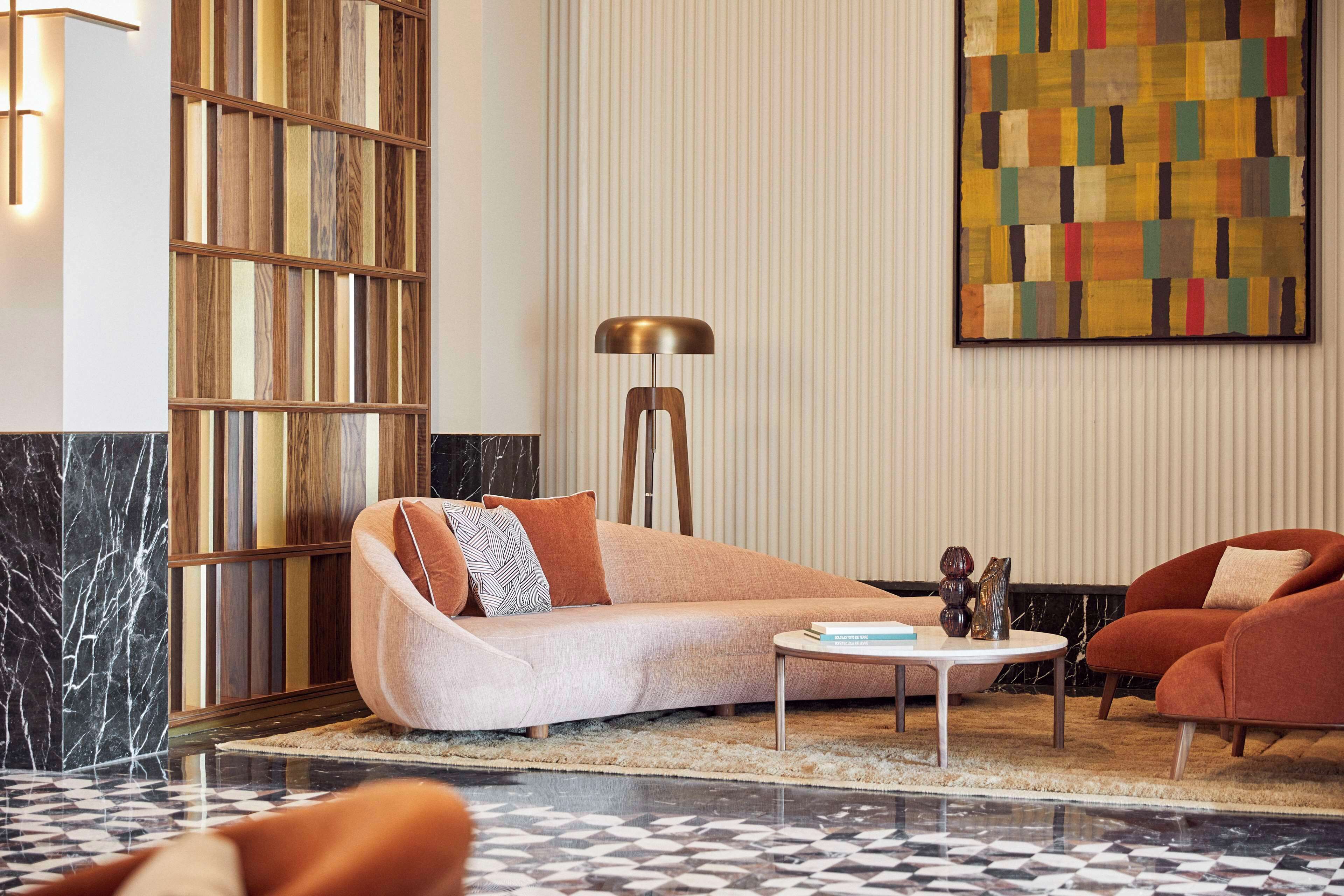 A modern living room with a sofa, armchairs, a coffee table, and a floor lamp.