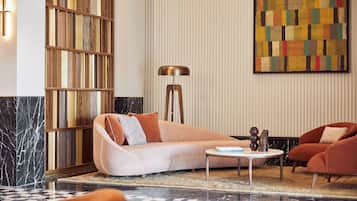 A modern living room with a sofa, armchairs, a coffee table, and a floor lamp.