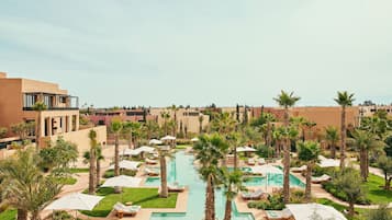 A resort with multiple swimming pools, palm trees, and lounge areas.