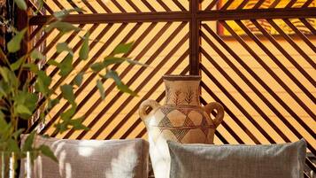 A room with a sofa, a glass table, and a decorative vase.