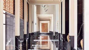 A hallway with black marble floors, white walls, and a central wooden panel. - Park Hyatt Marrakech (Marrakech)
