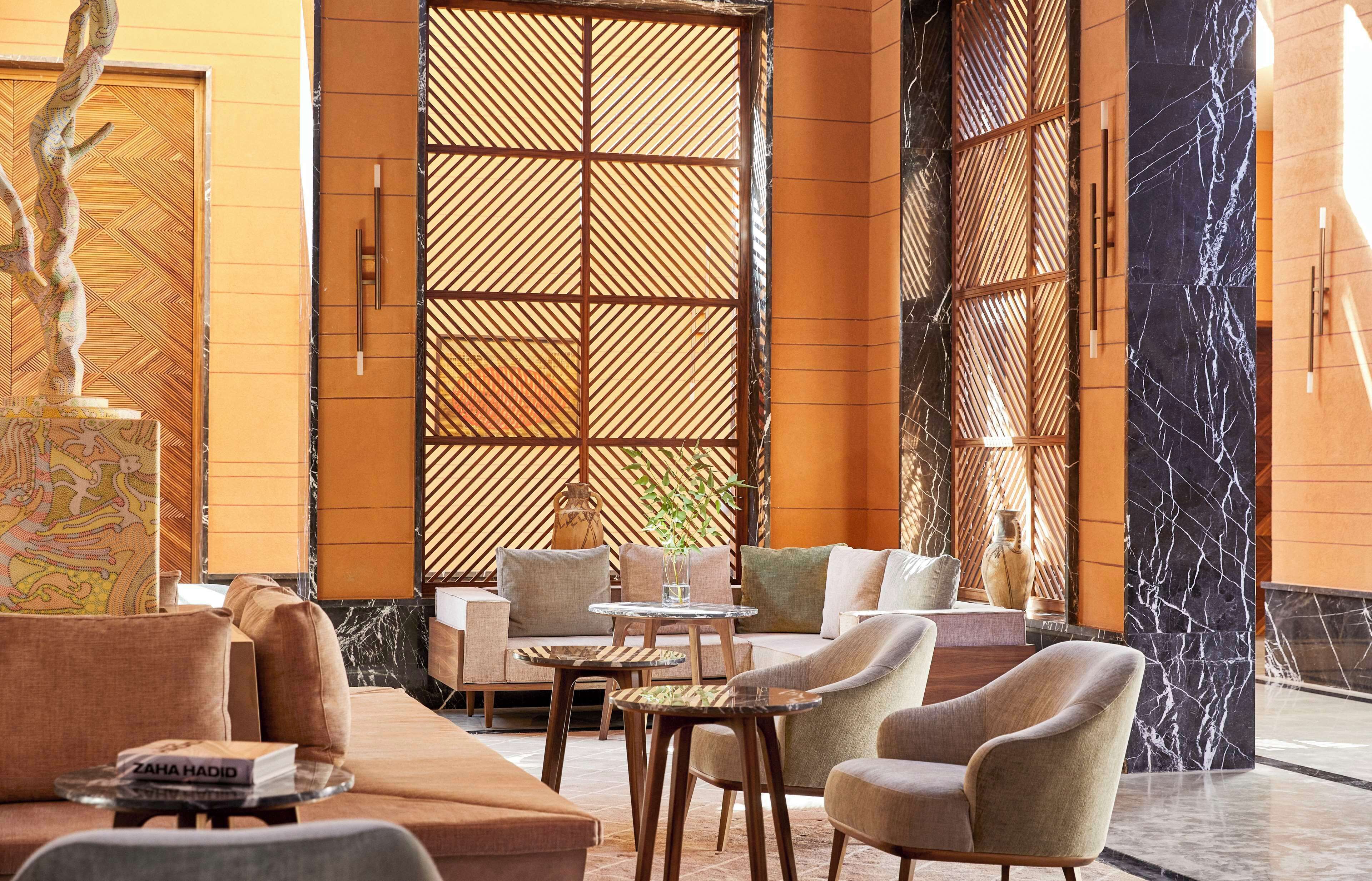 A modern lobby with a sofa, armchairs, and a small table.