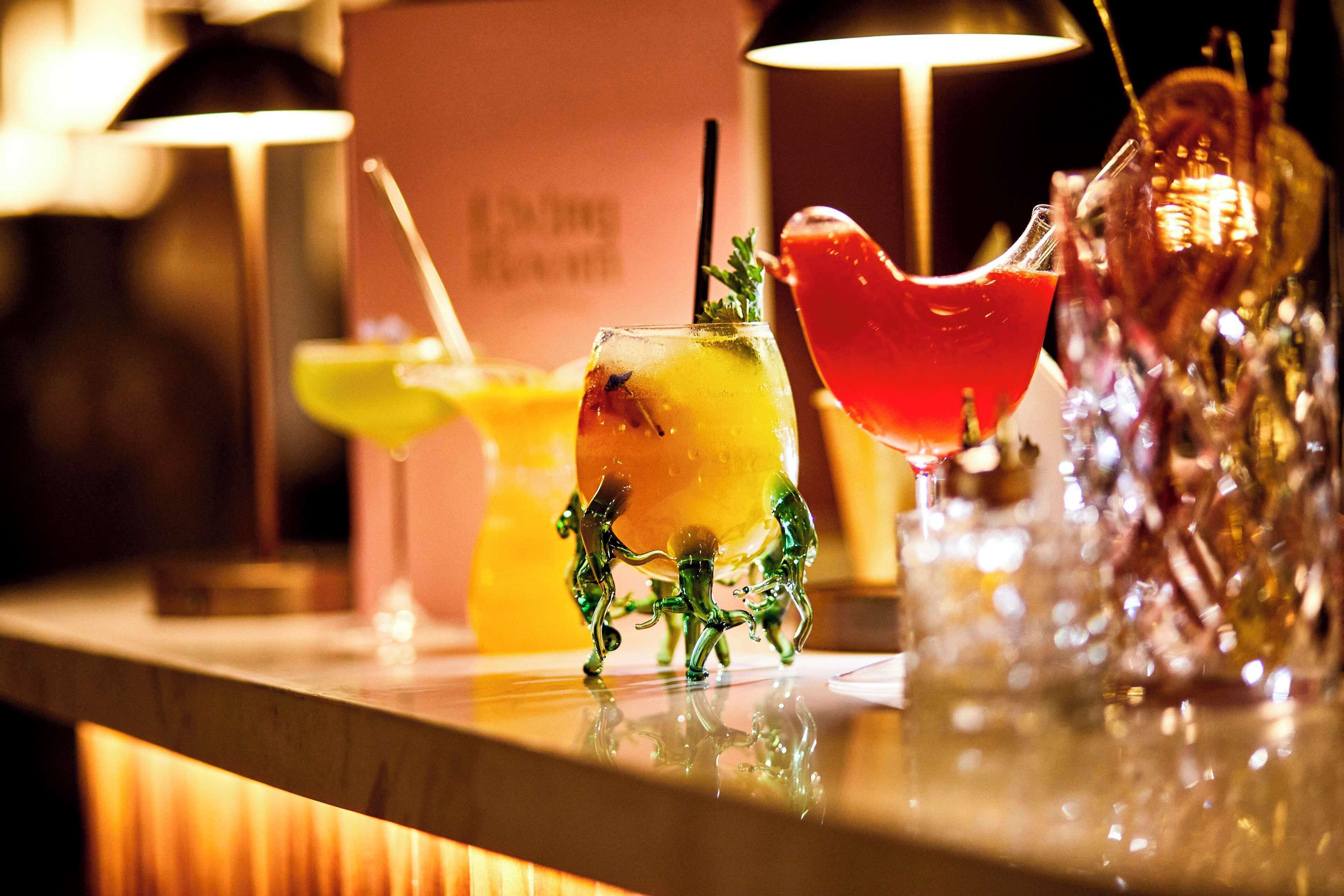 A bar area with various drinks and a decorative glass sculpture.