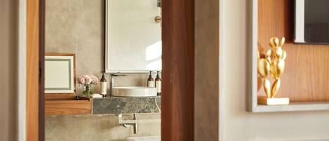 A modern bathroom with a large mirror, a sink, and a toilet.
