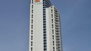A tall building with a prominent logo at the top. - Marco Polo - Pastel Studio with Stunning Aerial City Views (Dubai)