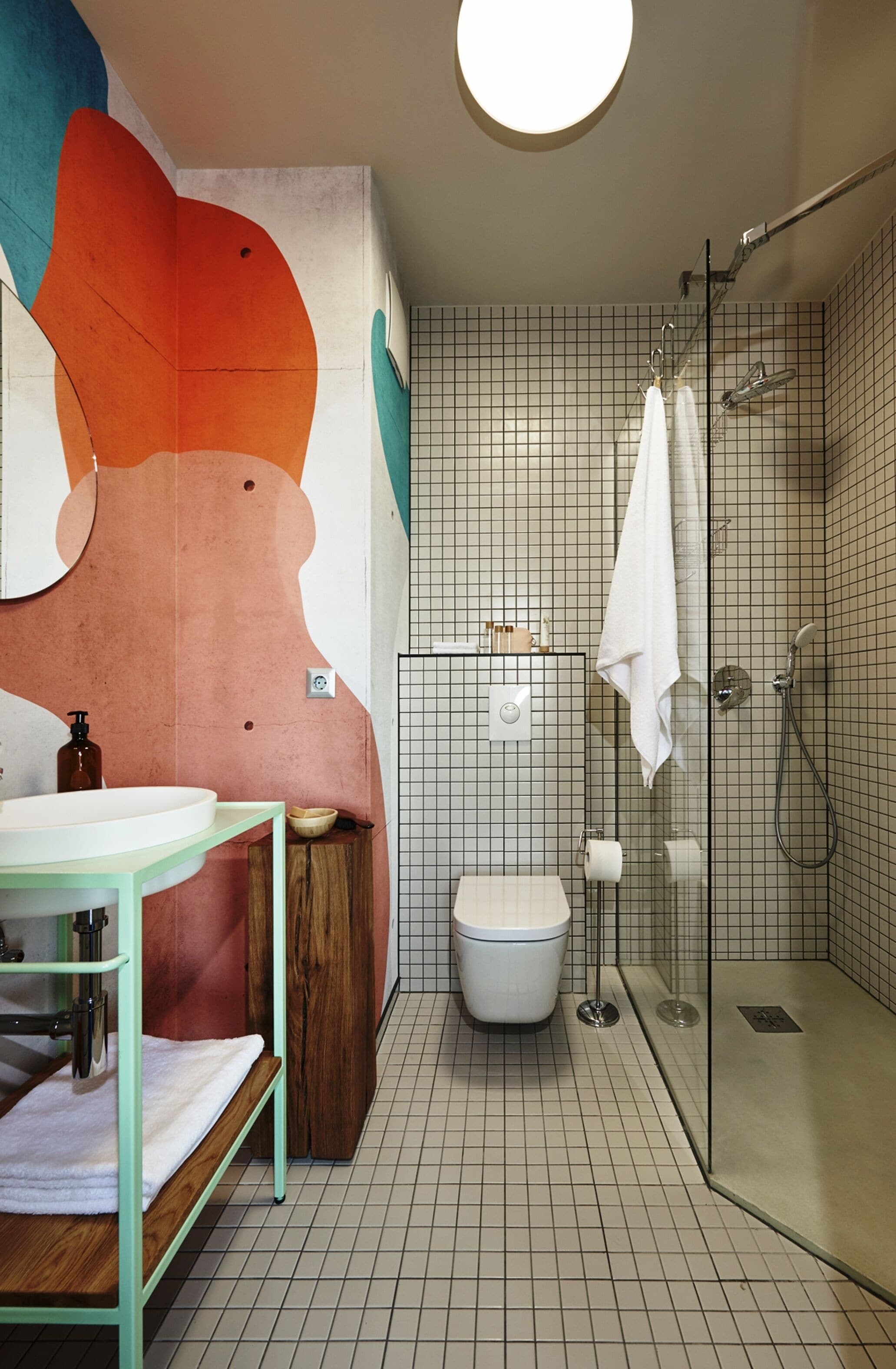 A modern bathroom with a glass shower enclosure, a white toilet, and a sink with a wooden vanity.