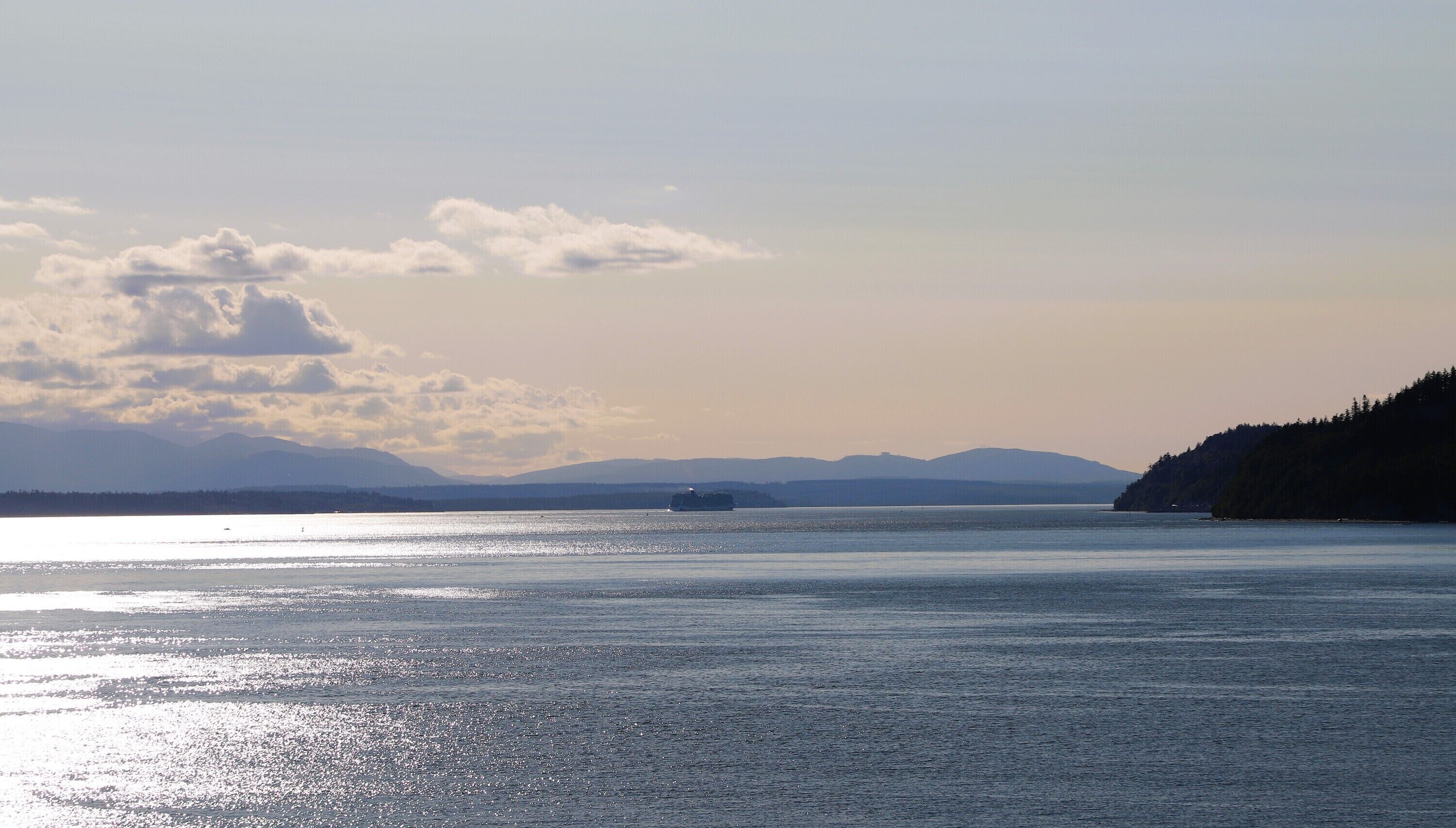 A body of water with a distant landmass and a ship.