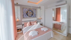 Un dormitorio moderno con una cama grande, una mesita de noche, un espejo y una lámpara en el techo.
