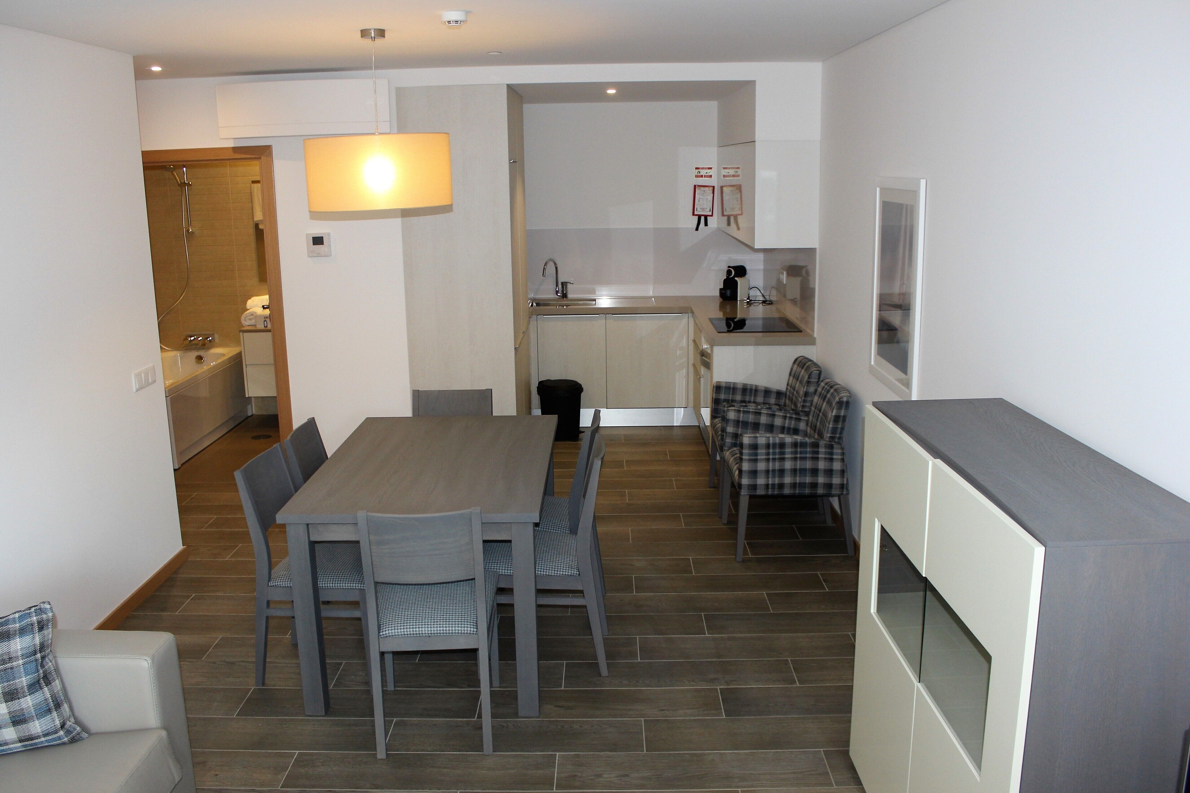 A compact living space with a dining area, kitchenette, and a small bathroom.