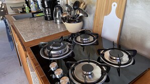 A kitchen with a gas stove, a coffee maker, and various kitchen utensils. - *LUXURIOUS 2 person STUDIO* (Noord)