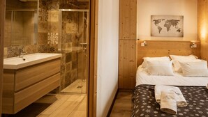 A modern bathroom with a glass shower enclosure, a wooden vanity, and a large mirror. - 4-room apartment, South facing, 6 people, pets allowed (Valloire)