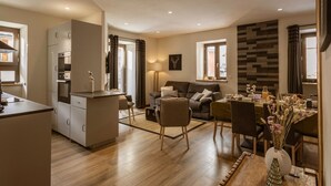 A compact living space with a kitchenette, a dining area, and a seating area with a sofa and chairs. - 4-room apartment, South facing, 6 people, pets allowed (Valloire)