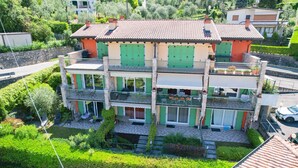 A two-story building with a balcony on the upper floor, surrounded by greenery. - MALCESINE DREAM APARTMENT (Malcesine)