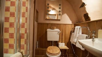 Une salle de bain avec des toilettes en bois, un lavabo et un espace douche.