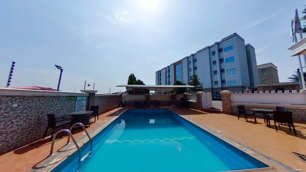 Une piscine avec vue sur un immeuble à plusieurs étages en arrière-plan.