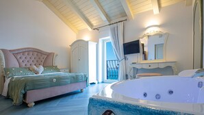 A bedroom with a large bed, a bathtub with a mural, a television, and a bathroom with a mirror and sink. - Spring Villa with panoramic views and private pool (Furore)