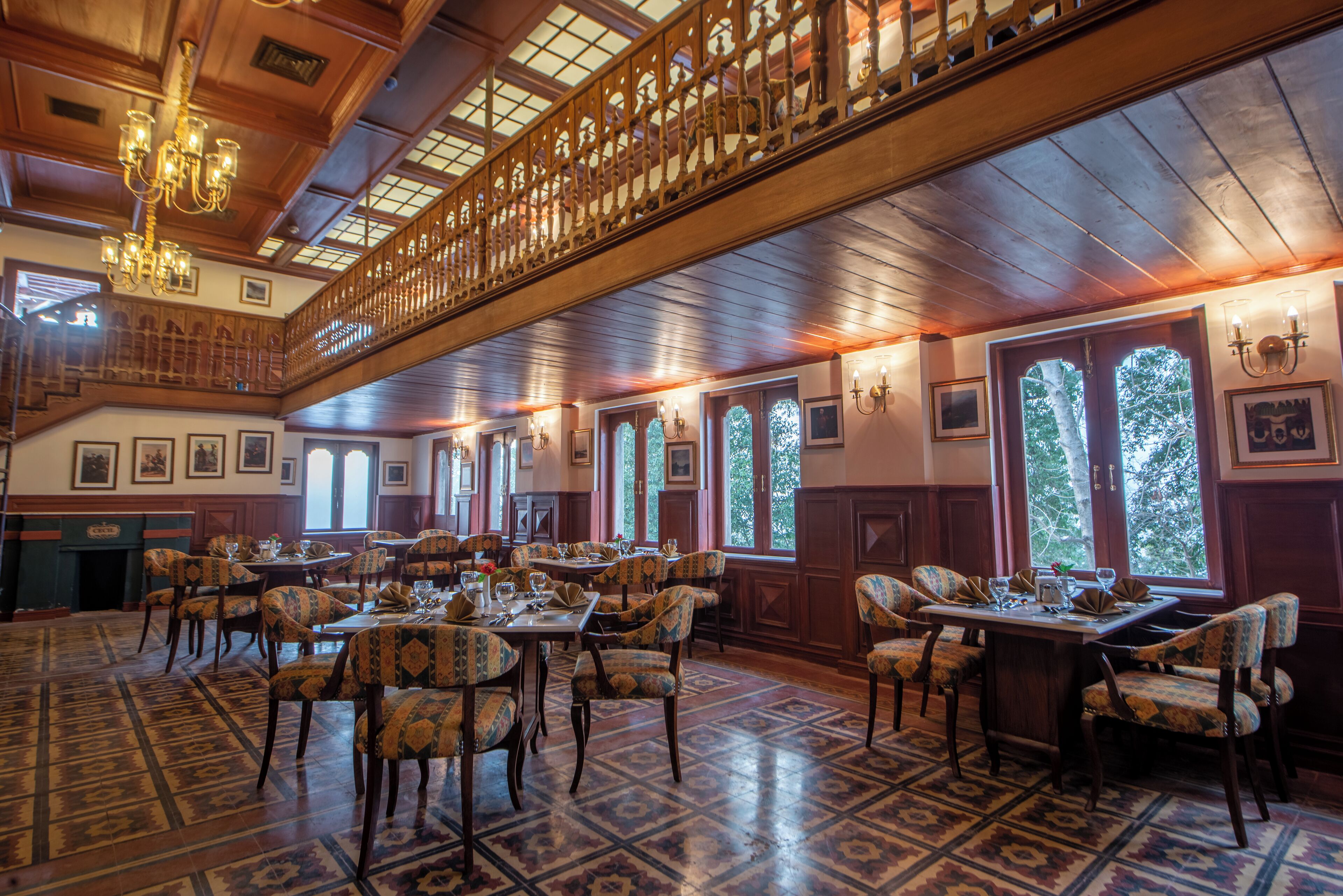 Un comedor espacioso con techos altos, paneles de madera y ventanas amplias.