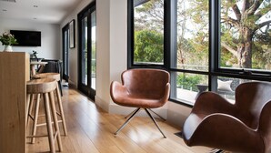 A modern interior with large windows, a wooden floor, and contemporary furniture. - Mi Casa Su Casa - stylish Interiors with Sauna! (Hepburn Springs)