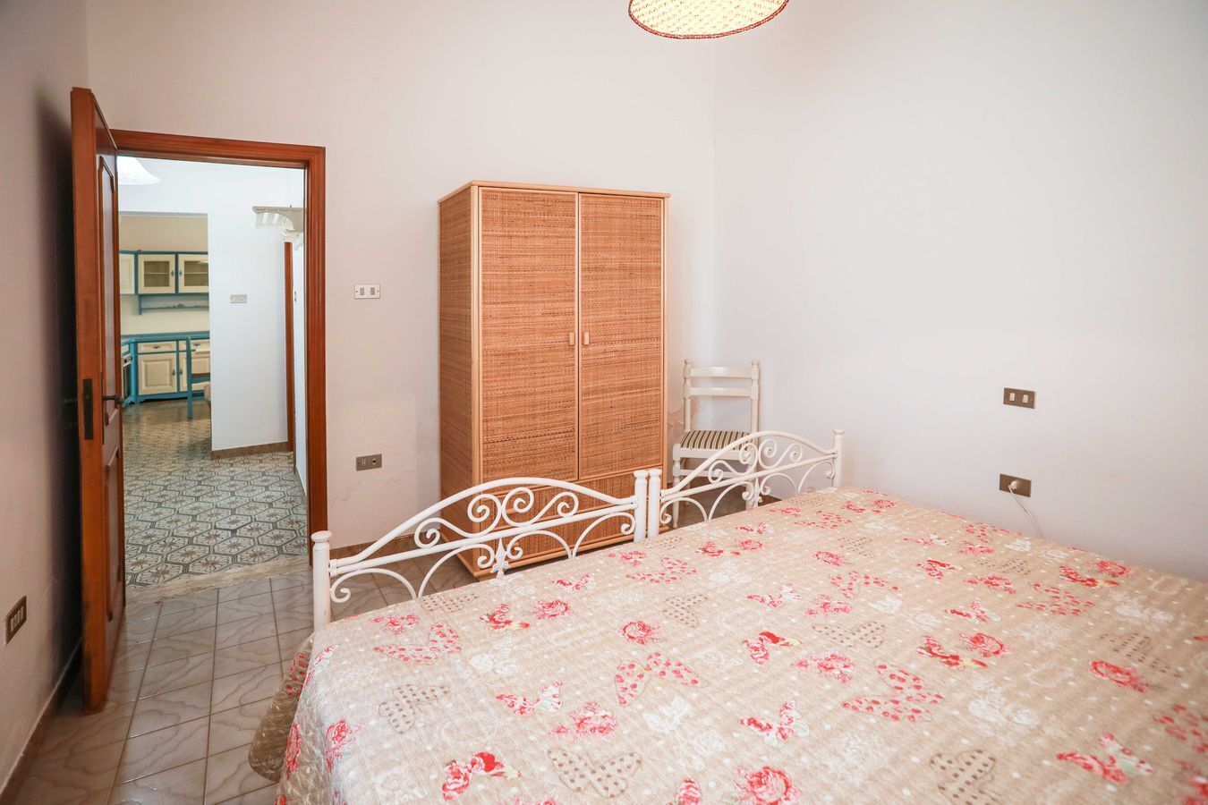 Quarto com cama, guarda-roupa e uma cadeira.