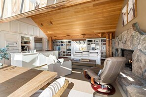 Un interior moderno con cocina, zona de estar y chimenea.