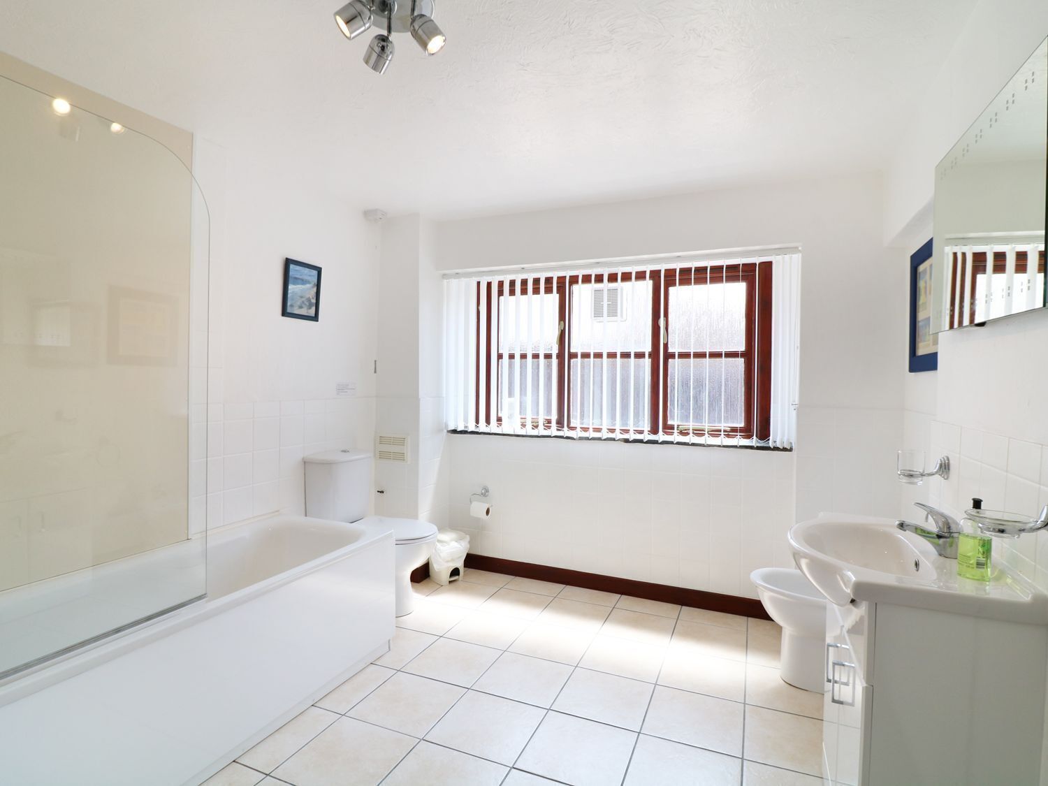 A modern bathroom with a bathtub, toilet, and sink.