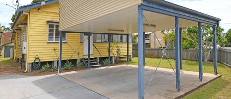 A yellow house with a covered patio area.
